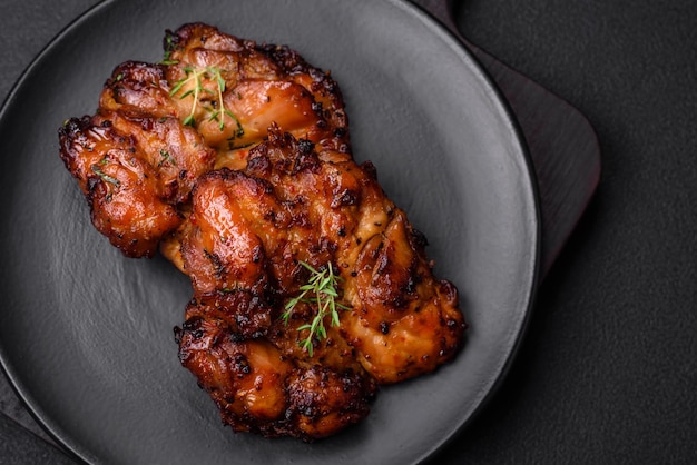 Deliciosa carne de pollo al horno con especias saladas y hierbas sobre un fondo de hormigón oscuro