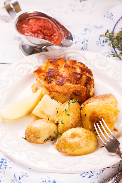 Deliciosa cena: papas al horno con tomillo y chuletas.