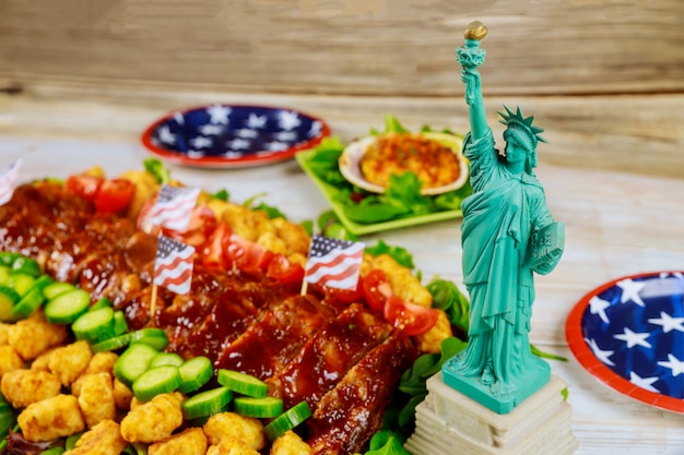 Deliciosa comida americana en la mesa de fiesta con la Estatua de la Libertad.