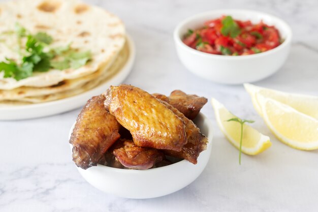 Deliciosa comida casera de tortillas, salsa y alitas fritas.