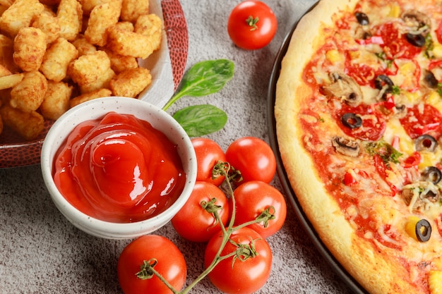 Deliciosa comida pizza, patata y tomate fresco en la mesa de madera.