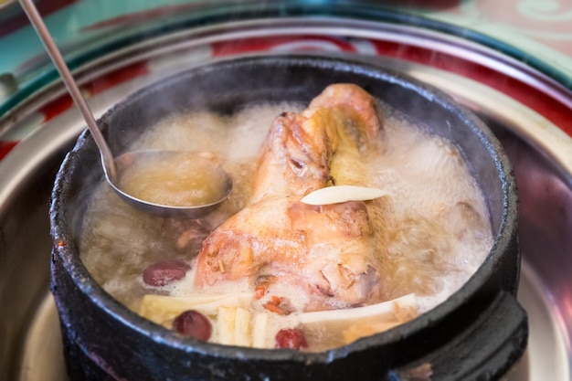 Deliciosa comida tibetana en olla de piedra para hervir pollo con algunos hongos silvestres