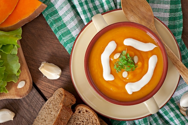 Deliciosa crema de calabaza en un recipiente sobre la mesa de madera