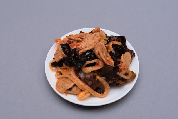 Deliciosa ensalada asiática de carne vegana de soja en un plato blanco sobre fondo gris Enfoque selectivo Concepto de comida asiática