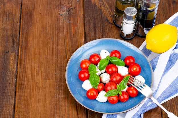 Deliciosa ensalada caprese italiana con albahaca, mozzarella y tomates cherry. Foto de estudio.