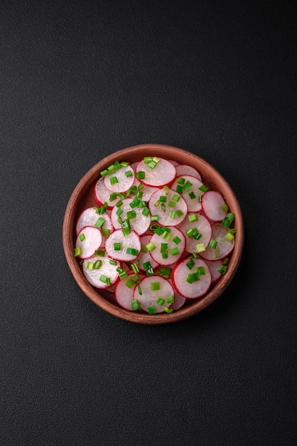 Deliciosa ensalada fresca de rábanos en rodajas con cebollas verdes, sal y aceite de oliva