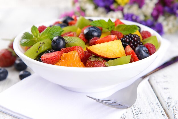 Foto deliciosa ensalada de frutas en un plato en la mesa de cerca