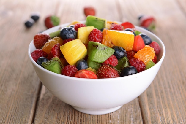 Deliciosa ensalada de frutas en un plato en la mesa de primer plano