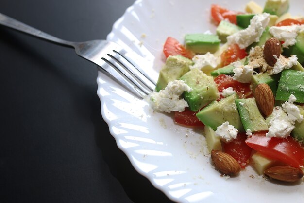 Deliciosa ensalada mediterránea de aguacate fresco con tomates cherry y almendras y queso feta parmesano