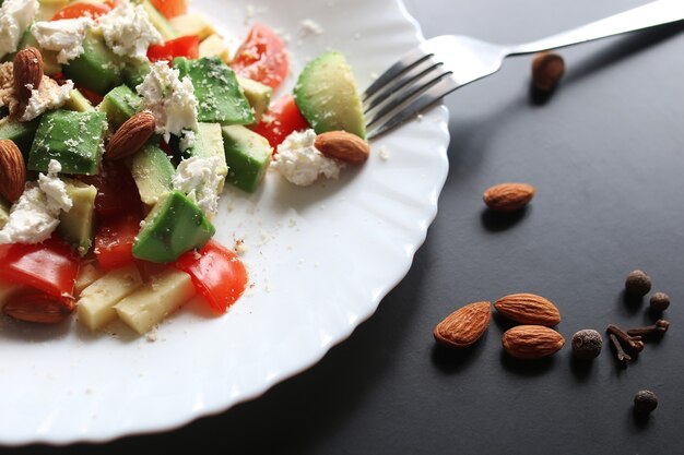 Deliciosa ensalada mediterránea de aguacate fresco con tomates cherry y almendras y queso feta parmesano