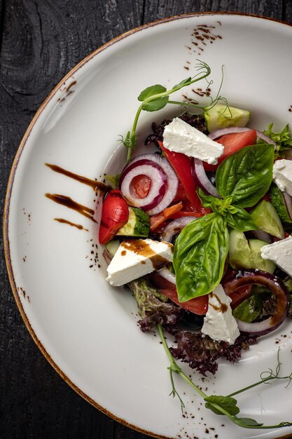 deliciosa ensalada en un plato sobre una mesa oscura