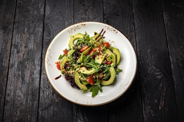 deliciosa ensalada en un plato sobre una mesa oscura