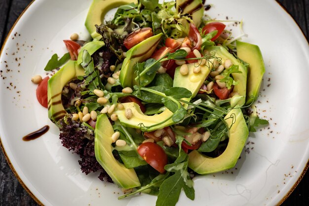 deliciosa ensalada en un plato sobre una mesa oscura