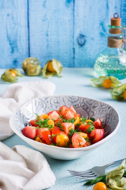 Deliciosa ensalada de tomates physalis y eneldo en un bol Comida vegetariana Vista vertical