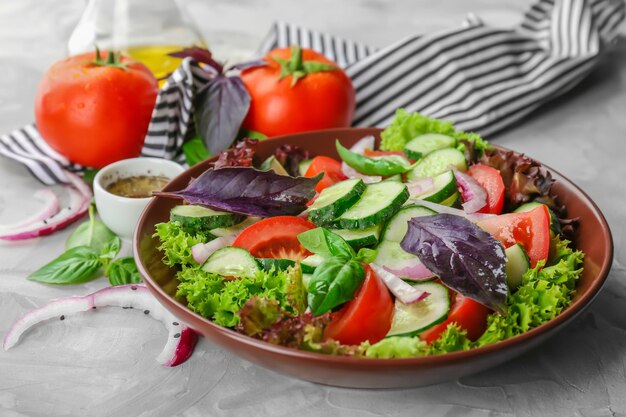 Deliciosa ensalada de verduras con pepinos en un tazón en la mesa