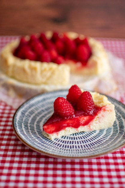 Deliciosa fatia de bolo de queijo decorando com framboesas