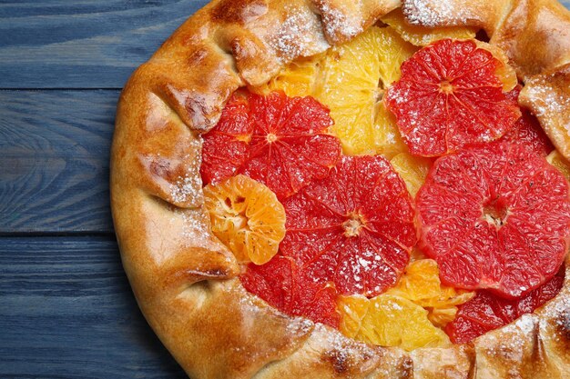 Deliciosa galette con frutas cítricas en primer plano de la mesa de madera azul