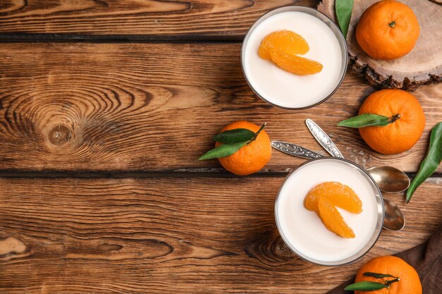 Deliciosa gelatina de mandarina y frutas frescas sobre una mesa de madera plana Espacio para texto