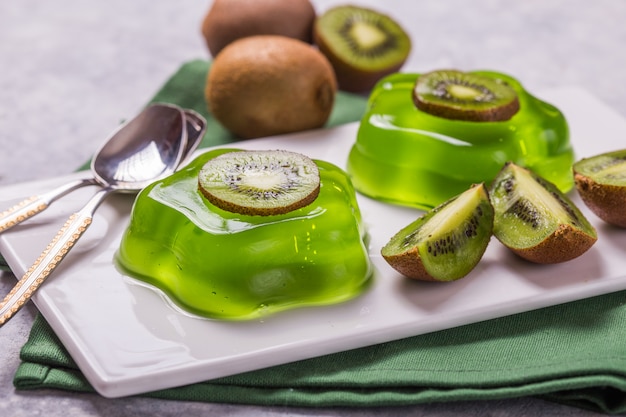 Deliciosa geléia verde fresca duas com fatias de kiwi na mesa de concreto