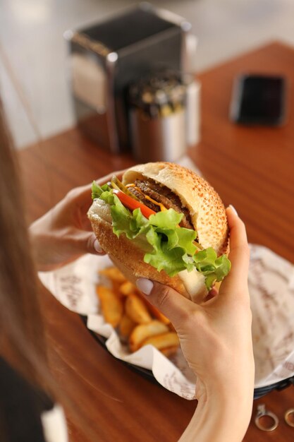 Deliciosa hamburguesa con carne de res a la parrilla, verduras, salsa. Concepto de comida rápida y comida chatarra.