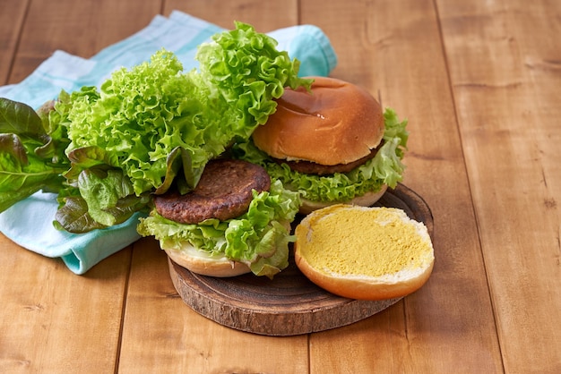 Foto deliciosa hamburguesa con ensalada verde en una mesa de madera