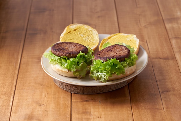 Deliciosa hamburguesa con ensalada verde en una mesa de madera