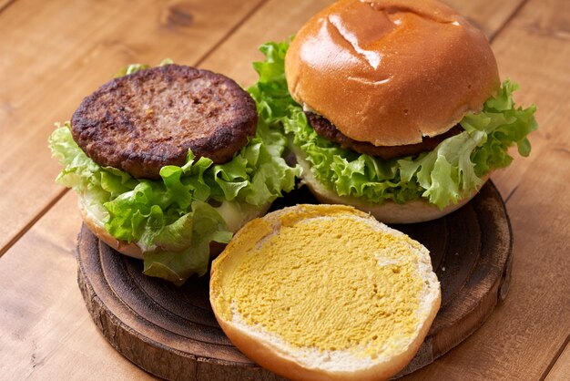 Foto deliciosa hamburguesa con ensalada verde en una mesa de madera