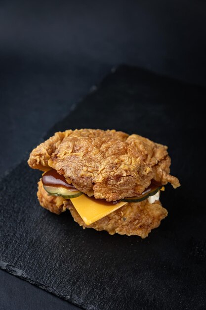 deliciosa hamburguesa hecha de carne de pollo, queso, pepinos en comida rápida