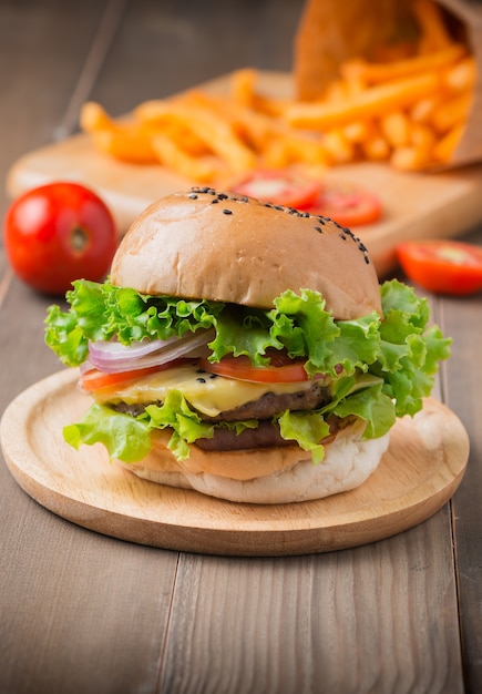 Deliciosa hamburguesa y papas fritas sobre fondo de madera