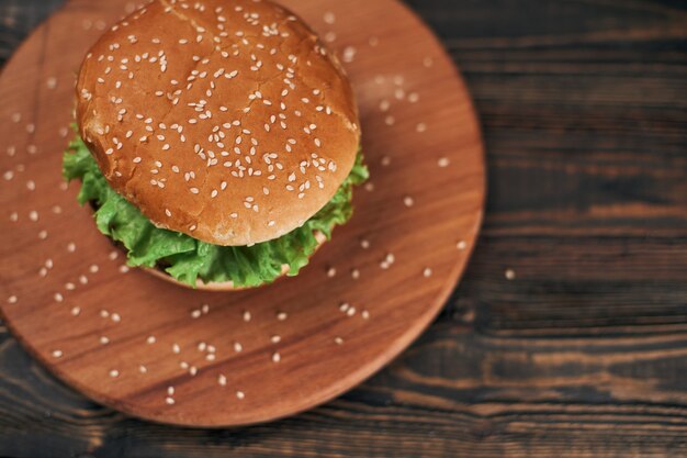 Deliciosa hamburguesa en una tabla de cortar de madera