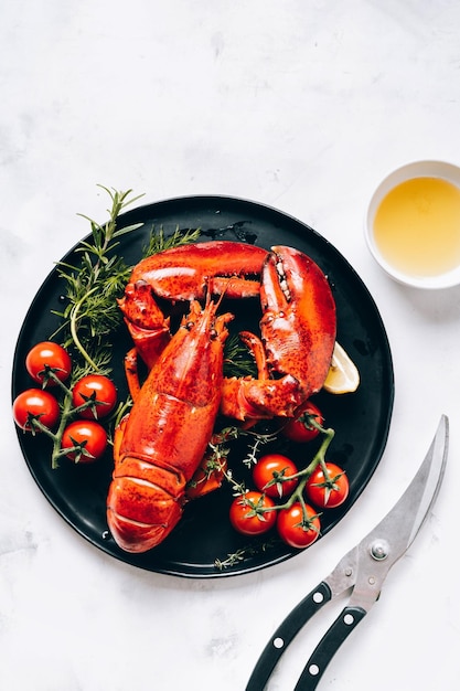 Deliciosa langosta gourmet en un plato negro y fondo blanco Vista superior