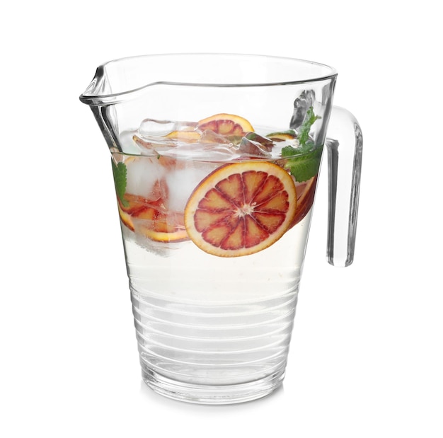 Deliciosa limonada refrescante con naranja roja en jarra de vidrio sobre fondo blanco.