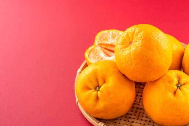 Deliciosa mandarina aislado sobre un fondo rojo.