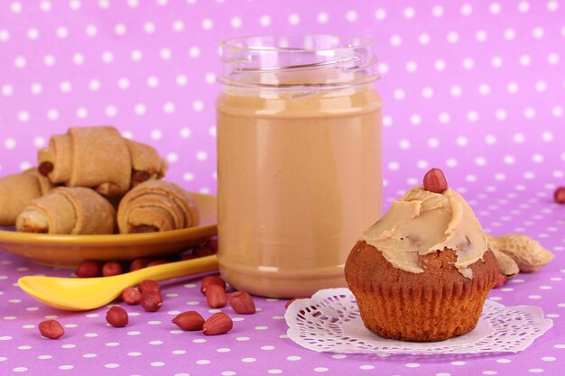 Deliciosa mantequilla de maní con galletas sobre fondo morado con lunares