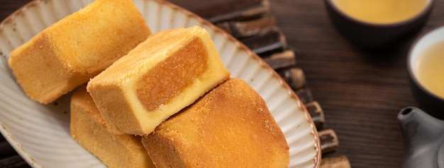 Deliciosa massa de bolo de abacaxi em um prato sobre fundo de mesa de madeira com chá