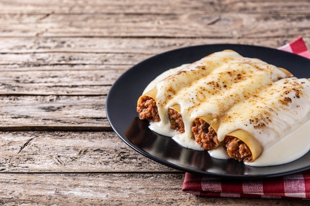 Deliciosa massa de canelone de carne na mesa de madeira