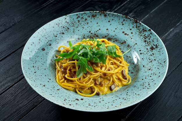 Deliciosa massa italiana carbonara com bacon e gema crua, parmesão e rúcula.