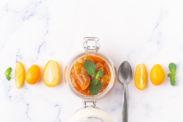 Deliciosa mermelada de kumquat en tarro de cristal con foto de alta calidad de menta