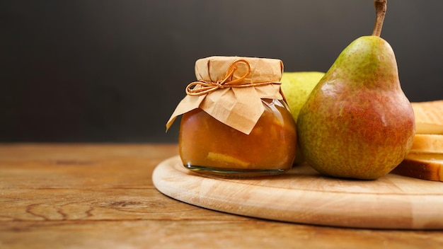 Deliciosa mermelada de pera y frutas frescas en tabla de cortar de madera Mermelada casera