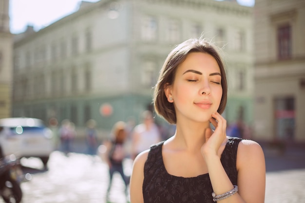 Deliciosa modelo morena com bronzeado bronze e maquiagem natural andando pela rua. Espaço para texto