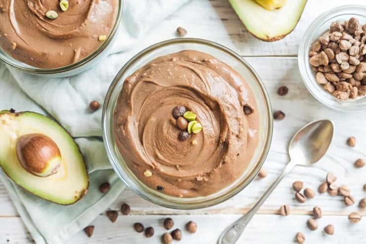 Foto deliciosa mousse de abacate de chocolate servida em elegantes tigelas de vidro em ambientes fechados