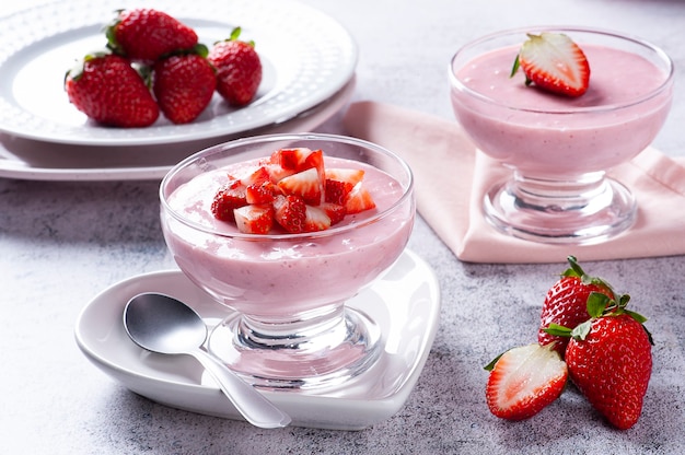 Deliciosa mousse de morango em uma tigela de vidro com morangos frescos.