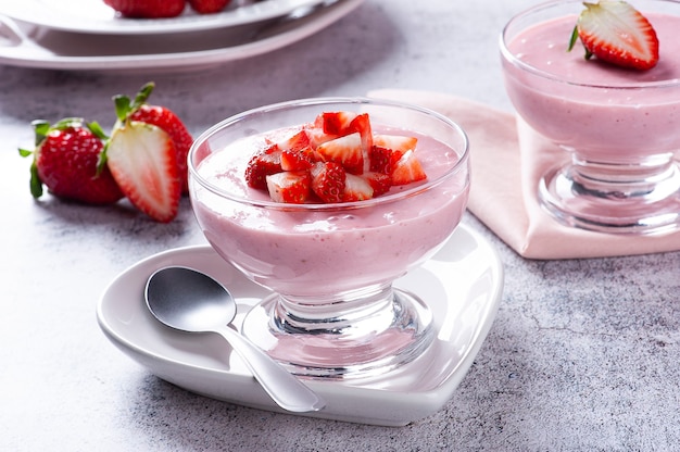 Deliciosa mousse de morango em uma tigela de vidro com morangos frescos.