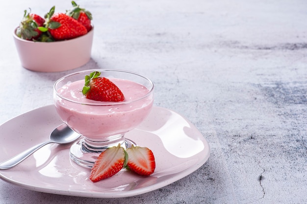 Deliciosa mousse de fresa en un tazón de vidrio con fresas frescas. Copia espacio