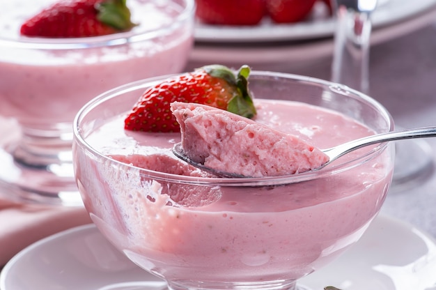 Deliciosa mousse de fresa en un tazón de vidrio con fresas frescas.