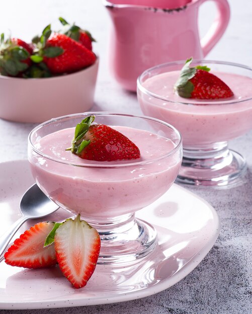 Deliciosa mousse de fresa en un tazón de vidrio con fresas frescas.