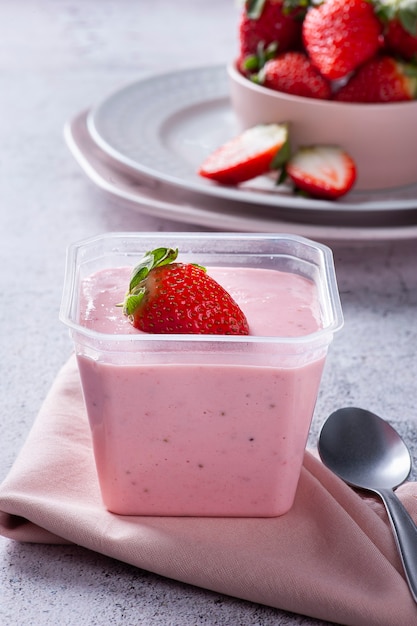 Deliciosa mousse de fresa en vaso de plástico para entrega con fresas frescas.