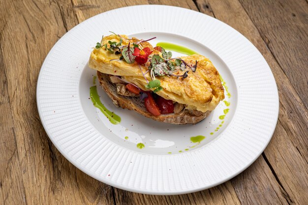 Deliciosa omelete de café da manhã com tomate na torrada Closeup