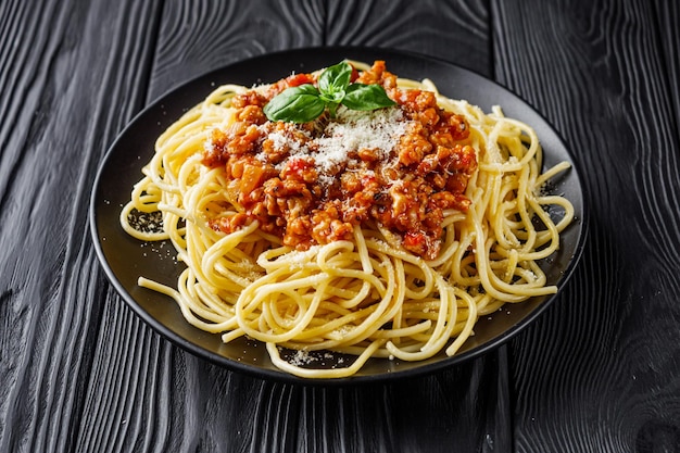 una deliciosa pasta bolognese en un plato negro