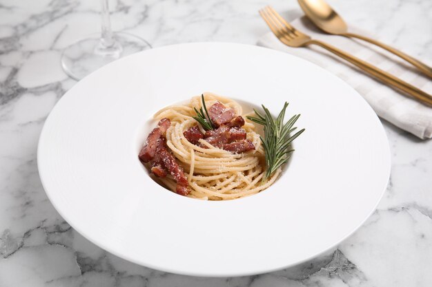 Deliciosa pasta Carbonara sobre mesa de mármol blanco